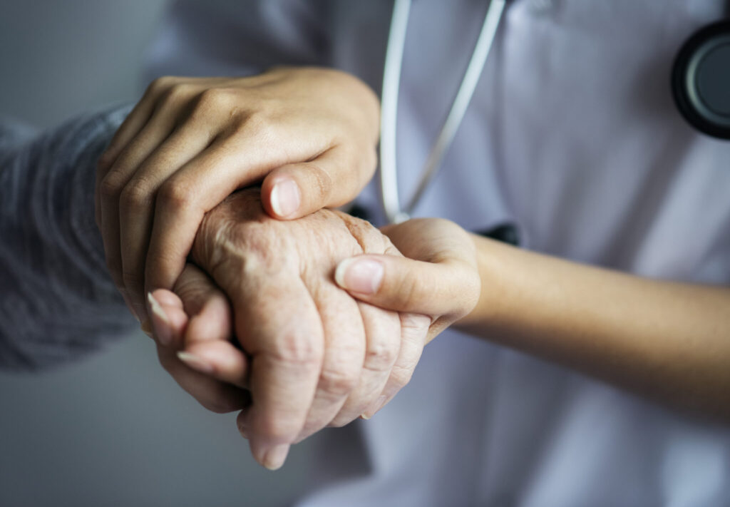 Pflegefachkraft hält einfühlsam die Hand einer Seniorin – ambulante Pflege und persönliche Betreuung im häuslichen Umfeld