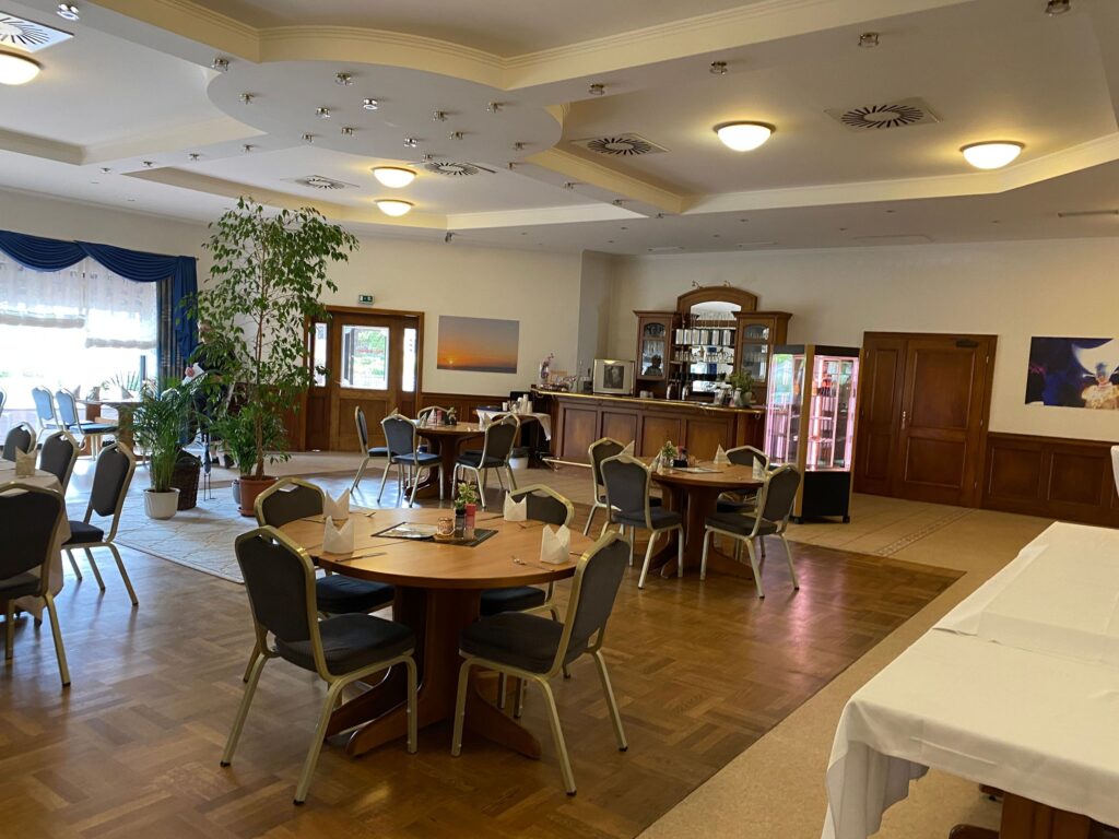 Innenbereich des Bistro zur Quelle in Minden – heller, barrierearmer Gastraum mit runden Tischen, Sitzgelegenheiten und gemütlicher Atmosphäre für gemeinsames Essen und Begegnung